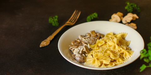 pasta farfalle with julienne mushrooms (fresh dish). food background. top