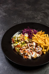 Turkish donner kebab with fries and salad on plate