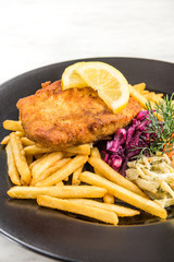 Pan fried fish with french fries and salad
