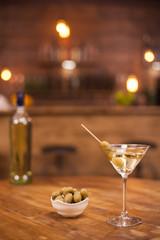 Relaxing in a pub with a glass of dry martini on a wooden table
