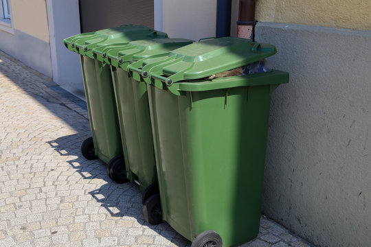 Green garbage cans are on the street