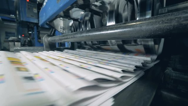 Folded newspaper on an automated belt, typographical machine.