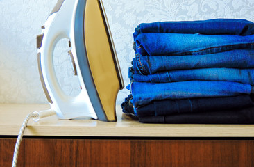Stack of colorful clean towels  on white background. Ironing clothes on ironing board. Stack of...