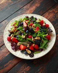 Fresh Fruit Salad with blueberry, strawberry raspberry, walnuts and green vegetables. healthy summer food