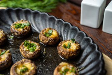 Traditional Italian Mushroom Caps stuffed with Feta as close-up in a rustic frying pan
