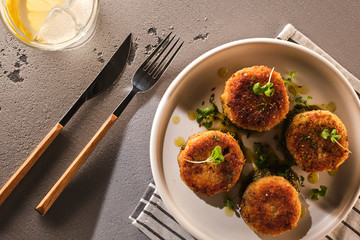 Fish cakes with sauce on a white plate, top view. Delicious homemade fish cutlets.