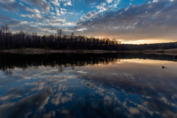 Clouds reflected on the water surface of the Pioneer pond shot in the spring at sunset