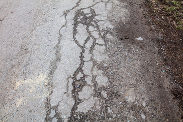 Cracks and pit on the asphalt road as background