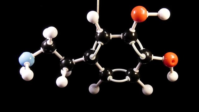 Dopamine C8H11NO2 molecule isolated on black background rotating
