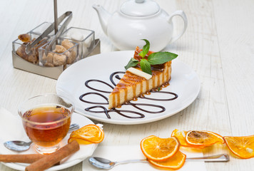 A piece of cake on a served table with tea