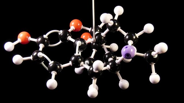 Morphine C17H19NO3 molecule isolated on black background rotating
