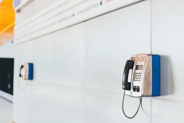 Close-up stationary public telephone at metro station in the afternoon