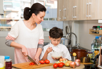 Woman and her son preparing food