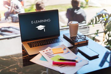Close up of laptop with inscription on screen e-learning on table in empty room, cafe. Distance...