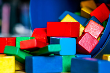 Colorful wooden building blocks on floor . Selective focus