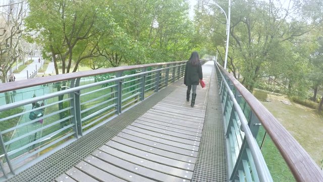 Raised wooden walkway in Xujiahui park Shanghai. In Xuhui park, an elevated wooden and glass walkway above the park, crossing it from one side to the other.