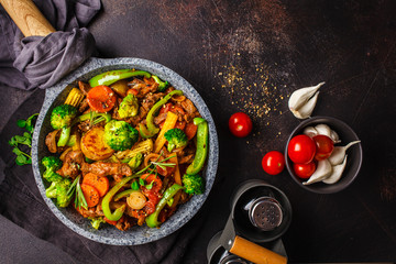 Fried beef stroganoff with potatoes and vegetables in a pan, top view.