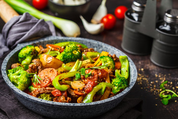 Fried beef stroganoff with potatoes and vegetables in a pan.