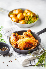 Grilled chicken and baked potatoes in a cast iron pan