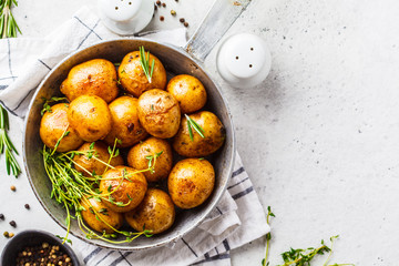 Baked potatoes in a cast iron skillet, top view. - obrazy, fototapety, plakaty