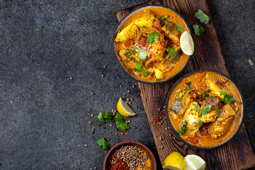 INDIAN FOOD. Traditional KERALA FISH CURRY with naan bread, gray plate, black background 