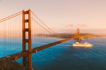 Fototapeta na wymiar Golden Gate Bridge with cruise ship at sunset, San Francisco, California, USA