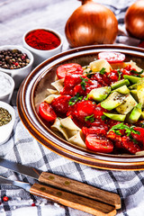 Pasta with herbs and vegetables on wooden background