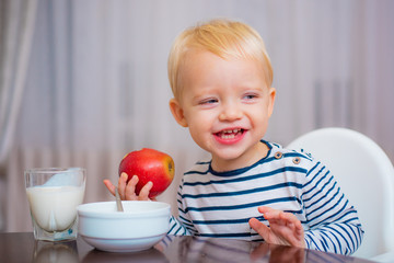 Kid cute boy sit at table with plate and food. Healthy food. Boy cute baby eating breakfast. Baby nutrition. Eat healthy. Toddler having snack. Healthy nutrition. Vitamin concept. Child eat apple