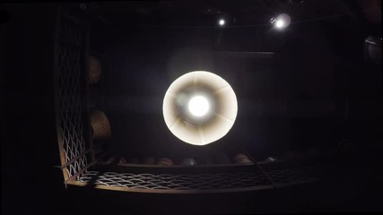 Bare swinging light in the darkness. In a creepy, scary old dusty room, a single lamp swings idly in the blackness. Suggests abandonment, hopelessness and feeling trapped.
