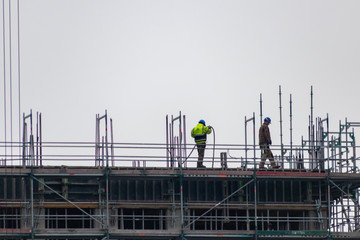 Bauarbeiter hoch oben auf einer Baustelle bereiten die Konstruktion vor