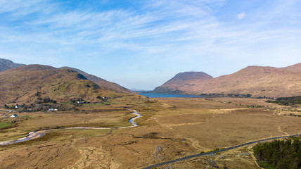 Panorama aérien sur un val du Connemara avec une route qui va vers un lac entre les montagnes 