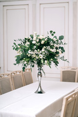 wedding decor, accessories, orchids, roses, eucalyptus, a bouquet in a restaurant, chairs table setting