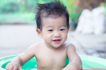 little children sit in basin and had fun playing water