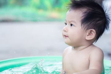 little children sit in basin and had fun playing water