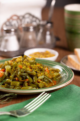 Braised green beans with carrots and mustard in a ceramic plate