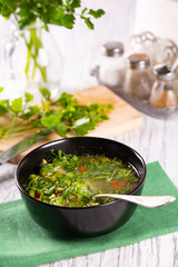 Fresh hot vegetable soup in a black plate on the table