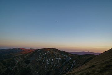 A little snow and moon above mountains sunset - landscape of the Ukrainian Carpathian Mountains, Chornohora