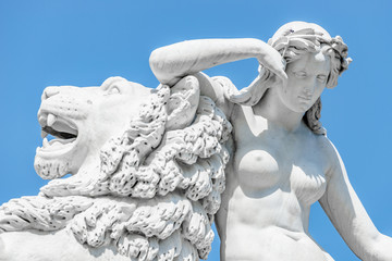 Ancient statue sensual renaissance era woman laying on big lion in Potsdam, Germany