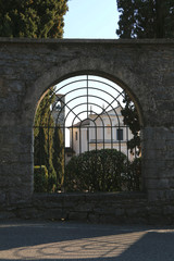 Old window in wall with view on the church of San Nicola da Bari in Gardone Riviera, Garda Lake, Italy.
