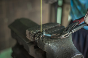 Worker with protective gloves welding metal part in workshop