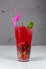 Lemonade with mint and cherry on a gray background. Refreshing drink or drink with ice