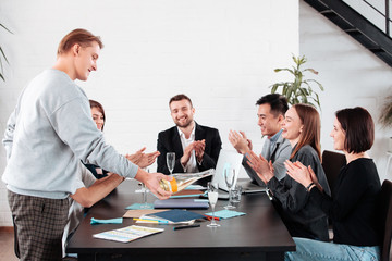 Well done work success young business people toasting each other and smiling while standing in the board room coworking, drink champagne celebrate christmas birthday new year contract