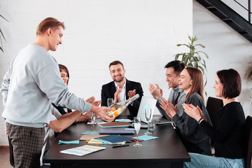 Well done work success young business people toasting each other and smiling while standing in the board room coworking, drink champagne celebrate christmas birthday new year contract