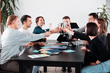 Well done work success young business people toasting each other and smiling while standing in the board room coworking, drink champagne celebrate christmas birthday new year contract