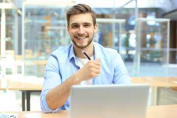 Fototapeta premium Portrait of young man sitting at his desk in the office.