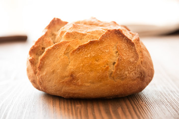 Loaf of wheat bread on wooden table