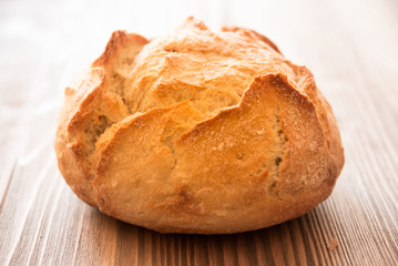 Loaf of wheat bread on wooden table