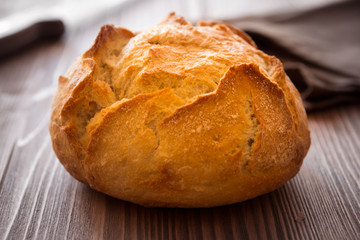 Loaf of wheat bread on wooden table