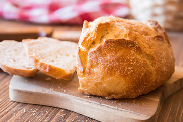 Sliced loaf of wheat bread on wooden table
