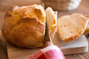 Sliced loaf of wheat bread on wooden table